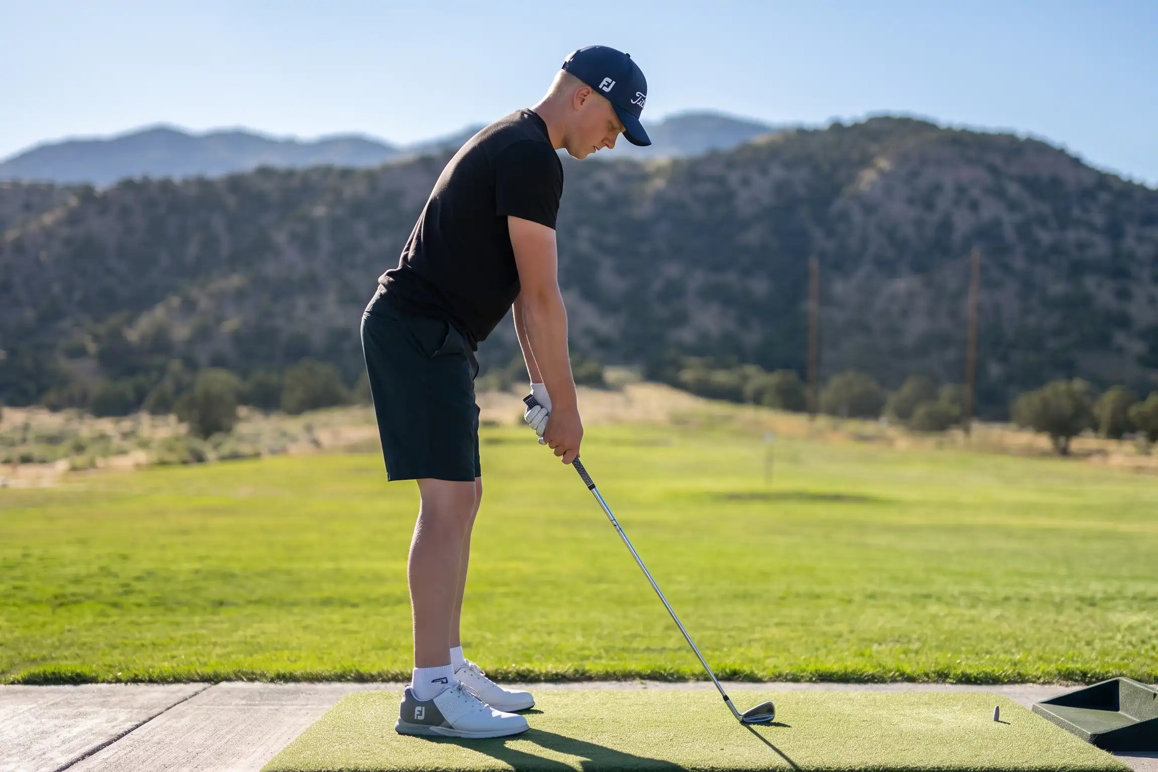 A golfer practicing his shot at the driving range